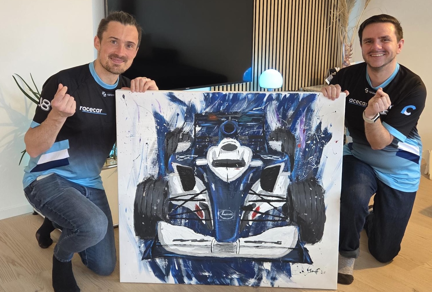 Felix and Daniel celebrate. Between them a painted picture of the RC-09, their first race car.